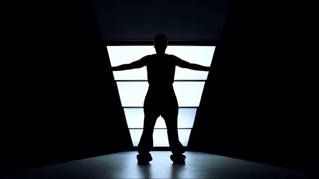 Dancer silhouetted against a glowing geometric doorway