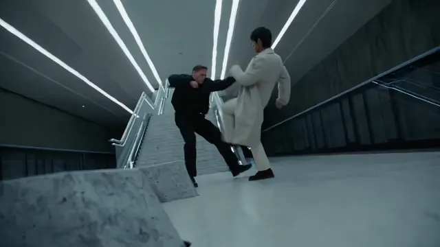 Two performers in an action scene on a concrete stairway