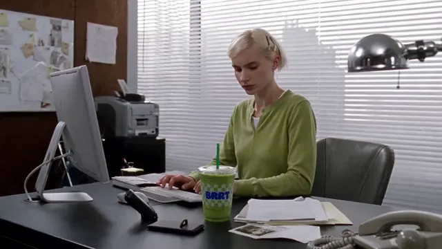 Woman in a green blouse working at an office desk
